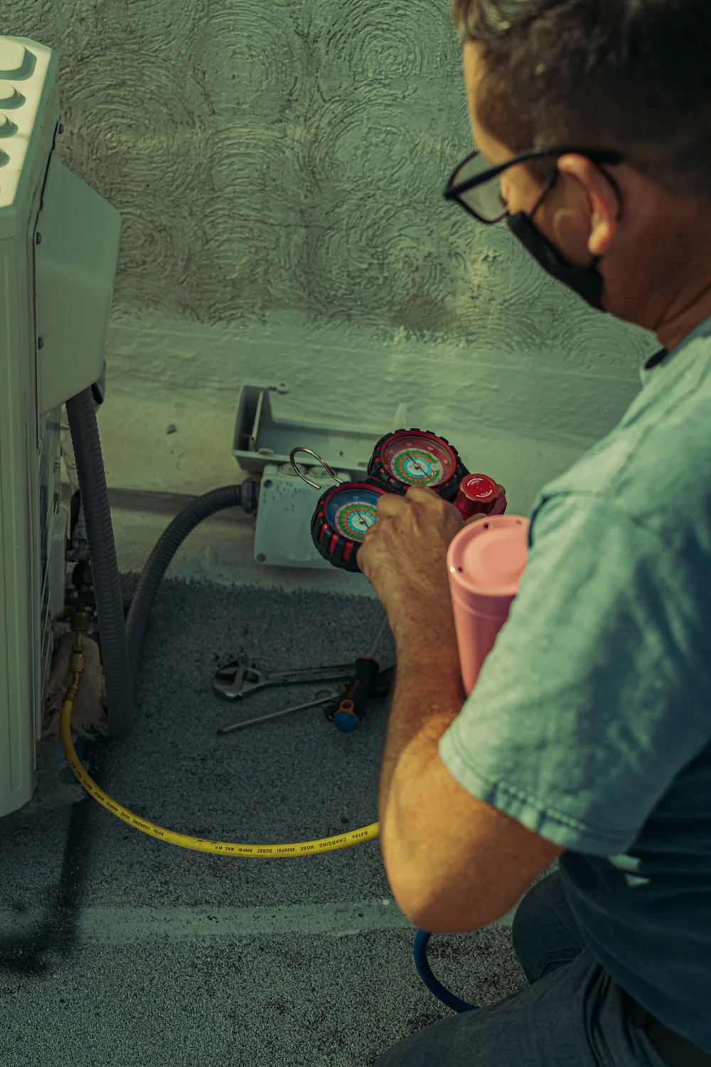 Illustrative stock photograph of a technician using gauges beside outdoor HVAC equipment; not Northline staff.